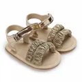 Detailweergave van gouden babysandalen met glitterende ruches en metallic afwerking - Goud