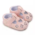 Detail van roze baby sandalen met hartvormige uitsparingen en zachte rubberen zool. - Roze