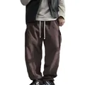 Detail view of men's brown corduroy cargo pants with loose fit and side pockets design - Brick Red