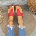 Primer plano de sandalias rojas con bordado de mariposa usadas con pantalones vaqueros. - Burdeos