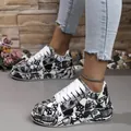 Detailed close-up of women's stylish black and white graffiti print platform sneakers. - 36 / Black