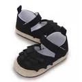 Vista dettagliata di scarpe da neonata nere con volant e suola morbida intrecciata. - 11cm / Nero