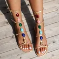 Rose gold flat gladiator sandals featuring colorful gemstone accents and buckled straps. - Champagne