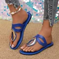 Close-up of blue flat sandals with large gold metal buckle and leather strap details - Blue