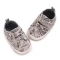 Top view of baby boy cartoon dinosaur sneakers with velcro straps on white background - White