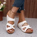 Detalle de sandalias de cuña blancas para mujer con diseño calado y costuras decorativas - Blanco