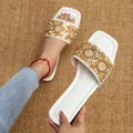 Detailopname van elegante witte platte sandalen met sprankelende gouden strass - 35 / Wit