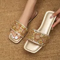 Detailopname van gouden platte slippers met strassteentjes en een vierkante neus - 35 / Goud