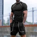 Detail van zwart heren sport compressieset met wit gestikte accenten op shirt en broek - S / Zwart