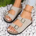 Detailaufnahme von beigen Sandalen mit Doppelschnalle auf weißem Kieselstein-Hintergrund - 35 / Gebrochenes Weiß