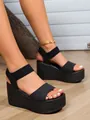 Macro view of stylish black platform sandals with woven wedge and elastic ankle strap - Black