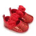 Nahaufnahme roter Glitzer-Babyschuhe mit großen 3D-Stoffblumen - Rot