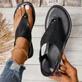 Close-up van zwarte platte zomersandalen met opengewerkt design en elastische band - Zwart