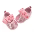 Close-up of sparkling pink glitter baby shoes featuring elegant chiffon flower accents - Pink