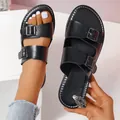 Nahaufnahme von schwarzen flachen Sandalen mit Doppelschnalle und klassischem offenem Design. - Schwarz
