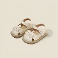 Elegant cream-colored baby girl sandals featuring a charming bow detail and secure velcro strap - Beige