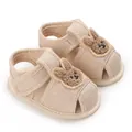 Gros plan de chaussures de marche pour bébé beiges avec patch lapin et semelle souple - Lapin