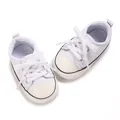Close-up view of white baby canvas shoes with soft soles for pre-walking babies. - Insole Length 11cm / White