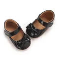 Top-down view of black patent leather baby girl Mary Jane shoes featuring a cute bow - Black