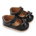 Detail van glanzende zwarte PU baby prinsessenschoenen met elegante strik en golfrand - Zwart