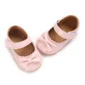 Close-up of pink PU baby girl pre-walker shoes featuring a delicate bow and scalloped trim. - Pink