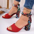 Detail view of red peep-toe sandals with floral print block heels and ankle strap. - 36 / Red