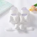 Detailansicht von weißen Baby-Spitzenschuhen mit Satinschleifen und passendem Stirnband. - Kissknoten-Stil (24-1)