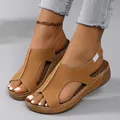 Detailed macro view of brown wedge sandals with decorative stitching and peep-toe design - 36 / Brown