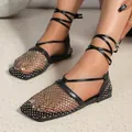 Close-up detail of black square-toe rhinestone mesh lace-up flat sandals on feet. - 35 / Black