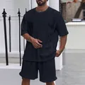 Detailansicht eines navyfarbenen Herren-Freizeitsets mit Zopfstrickmuster an Shirt und Shorts. - Marineblau