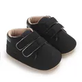 Détail en gros plan de baskets noires pour bébé avec doubles lanières auto-agrippantes. - Noir