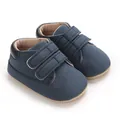Détail de chaussures de sport bleu marine pour bébé garçon avec brides velcro réglables. - Bleu