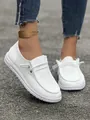 Primo piano di mocassini bianchi in velluto a coste da donna con texture a costine e lacci. - Bianco