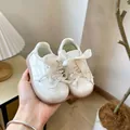 Gros plan de chaussures de marche blanches pour bébé avec nœuds en satin et semelle souple - Pointure 16 (Longueur Intérieure 12,0 cm) / Beige
