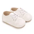 Vue détaillée de chaussures pour bébés à semelle souple blanche avec motifs brogues. - Blanc