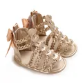 Detailansicht goldener Babysandalen mit geflochtenen Riemen und Satinschleife aus weichem PU - Gold