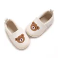 Detail von Baby-Lauflernschuhen mit süßem gesticktem Bären auf weißem Hintergrund. - Weiß