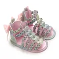 Detailansicht von rosa Glitzer Babysandalen mit geflochtenen Riemen. - bunt