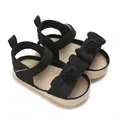 Detalle de sandalias negras para bebé niña con un lazo y suela de paja trenzada - Negro