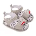 Close-up detail of grey baby sandals featuring cute cartoon shark and soft star print sole - Gray