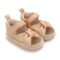 Close-up view of elegant baby shimmer gold sandals featuring a bow knot and woven soft sole - Gold