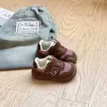 Close-up of toddler walking shoes with soft soles and breathable mesh in brown and pink - Brown