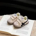 Detailansicht von gemütlichen, gefütterten Kleinkind-Sneakern mit Klettverschluss für Winter. - Beige