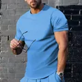 Dettaglio di una t-shirt da uomo blu brillante a girocollo con maniche corte su un modello - Taglia S / Top / Azzurro