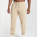 Detail view of men's beige joggers with drawstring waist and central seam detail - Apricot