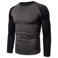 Close-up of a men's grey and black color-block long-sleeved T-shirt with a crew neck. - M / Tops / Dark Grey Patchwork Black