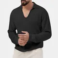 Nahaufnahme eines schwarzen Polo-Shirts aus Waffelstrick mit V-Ausschnitt und Stoffstruktur. - Schwarz