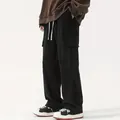 Dettaglio dei pantaloni cargo da uomo in velluto a coste nero con gamba larga e coulisse. - Nero