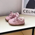 Primer plano de zapatillas de gamuza rosa para niños pequeños con suelas suaves - Rosa