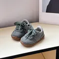Detalle de zapatillas grises para niños pequeños con cordones verdes y suela blanda - Verde Militar